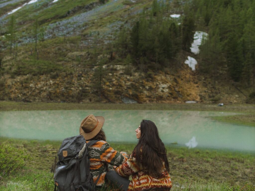 couple sitting beside a lake