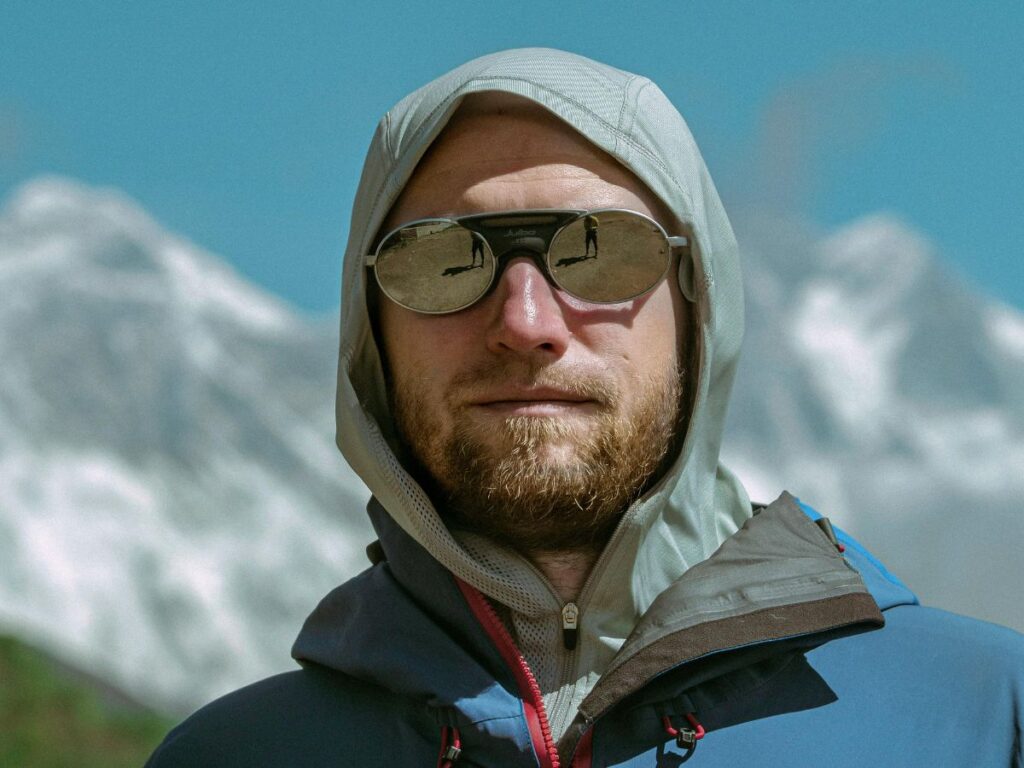 man standing in snow wearing glasses for hiking