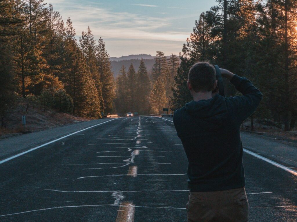 man capturing photo of road to yosemite